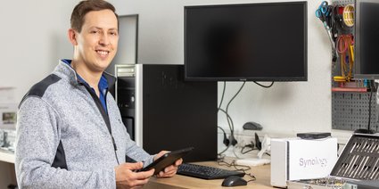 IT-Mitarbeiter im Büro in Obergünzburg bei der Präsentation eines Android oder iOS-Tablets. Gerne hilft er auch Ihnen bei der Reparatur Ihres Tablets.